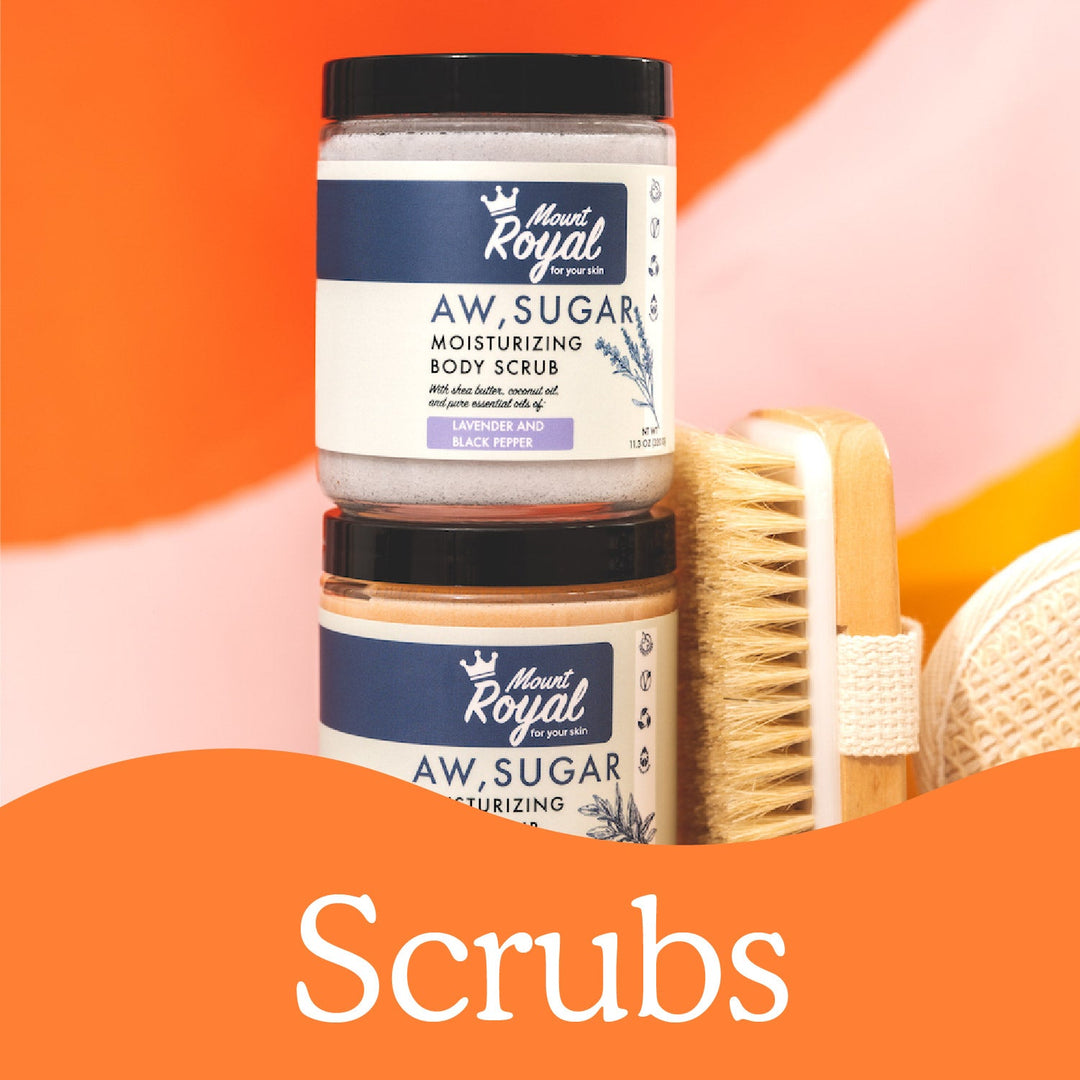 Mount Royal sugar scrub jars with a body brush and an orange Scrubs banner.