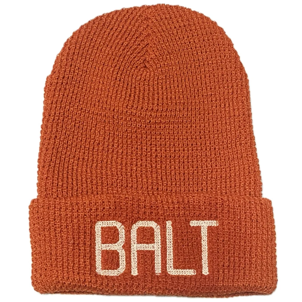 Rust red knit beanie with 'BALT' embroidery
