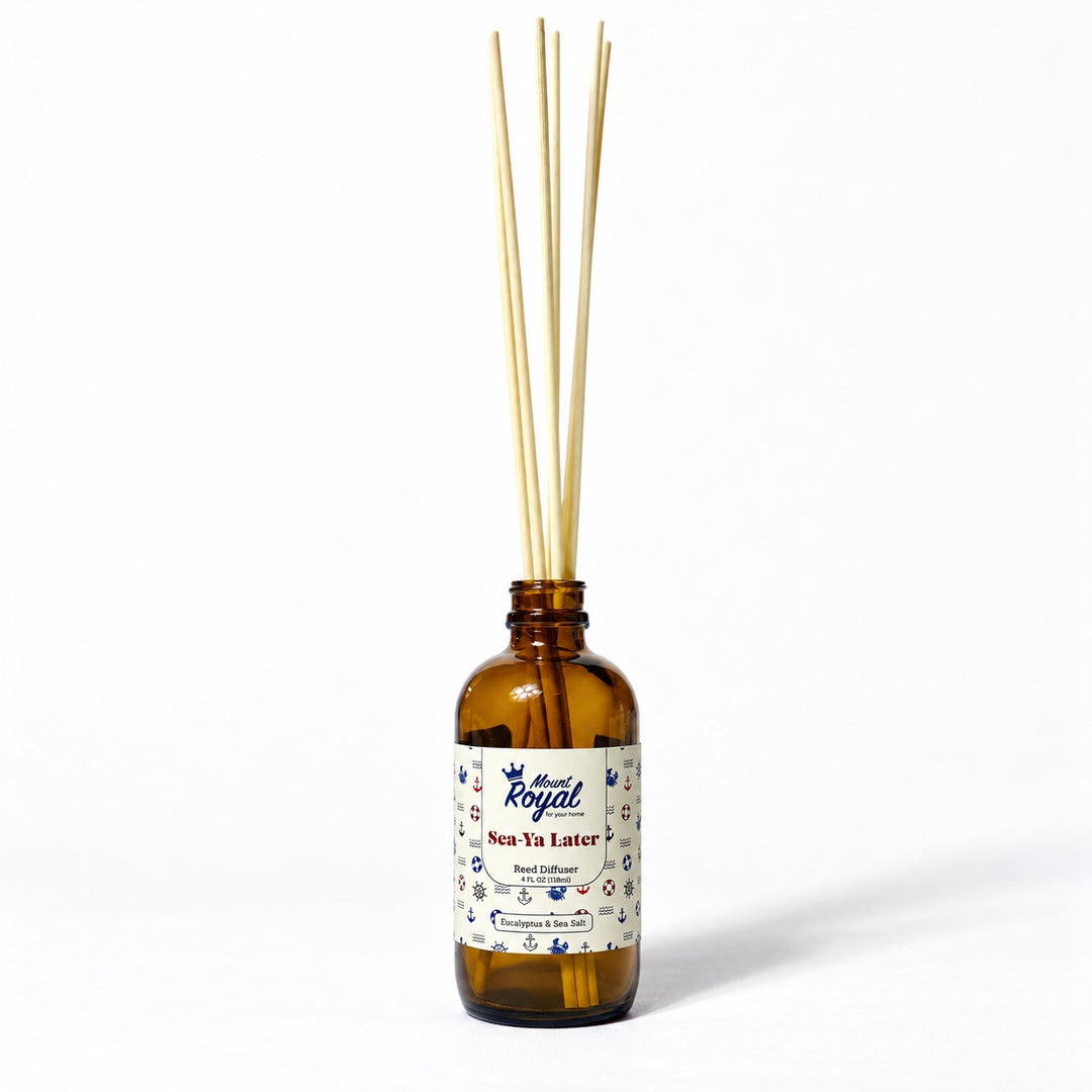 Sea Ya Later Reed Diffuser in an amber glass bottle with reeds on a white background