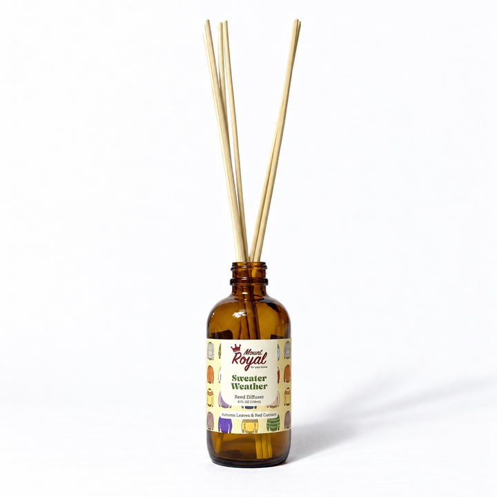 Sweater Weather Reed Diffuser in an amber glass bottle with reeds on a white background
