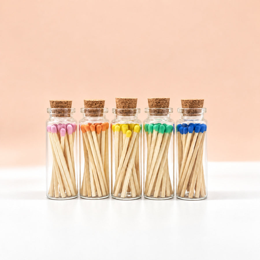 Glass jars of colorful matches on a peach background